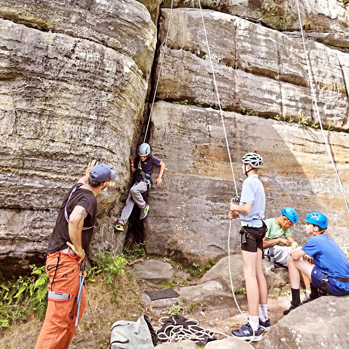 Year 8 students participating in an outdoor climbing session at Harrison's Rocks with qualified instructors.